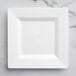 A white square Visions Florence plastic plate on a marble surface.