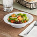 A salad in a Visions white plastic bowl on a table.