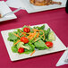 A Visions Florence ivory plastic plate with a salad of broccoli, carrots, and tomatoes.