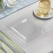 A Visions Florence clear square plastic plate with a knife and fork on a table.