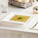 A Visions white square plastic bowl filled with soup on a table.