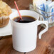 A white Visions plastic coffee mug with a straw in it.