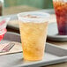 A tray with two Dart translucent plastic cups filled with drinks.