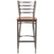 A Clear-Coated metal restaurant barstool with a cherry wood seat.