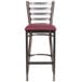 A Flash Furniture metal restaurant barstool with a burgundy vinyl seat.