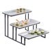 An American Metalcraft three-tier rectangular display stand with food on it.