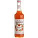 A bottle of Monin Premium Mandarin Fruit Syrup on a white background.