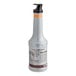 A Monin 1 liter bottle of peach fruit puree with orange and brown labels and a black lid.