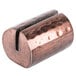 A close up of an American Metalcraft copper colored metal clip with a hole in it.