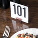 An American Metalcraft rectangular hammered copper table card holder on a wood table with a plate of food.