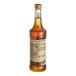 A brown Monin bottle of liquid with a brown label.