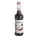 A bottle of Monin dark chocolate flavoring syrup with a white label.