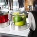 A Cal-Mil wooden display with two glass jars of limes on a counter.