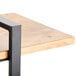 A Cal-Mil Madera rustic pine 3-shelf metal frame riser with a black frame on a wood table.