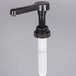 A black Monin plastic pump with a white plastic tube.
