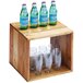 A wooden cube riser holding six bottles of water and glasses on a table.