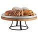 A Cal-Mil Madera rustic pine cake pedestal with pastries on a table.