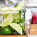 A Cal-Mil rustic pine riser with a glass jar of limes on a counter.