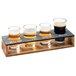 A Cal-Mil Madera rustic pine tasting flight on a table with four glasses of beer.