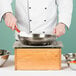 A chef using a Cal-Mil Madera butane range frame to cook in a pan.