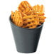 A black concave bowl filled with crinkle cut french fries.