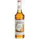 A bottle of Monin Spiced Brown Sugar syrup with a white label.