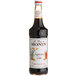 A bottle of Monin Premium Sugarcane Cola flavoring syrup with a white label.