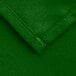 A close up of a green Intedge square cloth table cover with a hemmed edge.