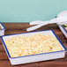 Three white Cal-Mil enamelware trays with blue rim on a table with macaroni and cheese.