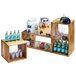 A wooden shelf on a table with drinks and glasses using a Cal-Mil Madera building block system.