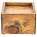 A wooden square box with a hole in the middle and a wooden handle.