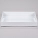 A white rectangular Cal-Mil plastic room service tray with handles.