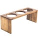 A wooden stand with three holes for flatware.