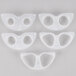 A group of four white plastic objects with two holes in each.