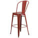 A Flash Furniture red metal bar stool with a backrest.