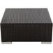 A BFM Seating Aruba Java wicker coffee table with a metal base on an outdoor patio.