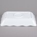 A white rectangular melamine tray with scalloped edges.