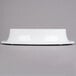 A white round Elite Global Solutions melamine pedestal with a black rim on a gray surface.