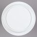 An Elite Global Solutions white melamine pedestal plate on a gray surface.