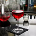 A close-up of a Spiegelau red wine glass filled with red liquid on a table.