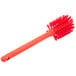 A red Carlisle Sparta Spectrum bottle cleaning brush with a handle.