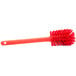 A close-up of a red Carlisle Sparta Spectrum bottle cleaning brush with a handle.