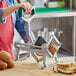 A woman using a Garde heavy-duty French fry cutter to make potato wedges.