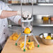 A person using a Garde Wedge Cutter to cut up an orange.