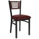 A BFM Seating black metal side chair with a walnut back and burgundy seat.