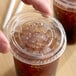 A clear flat PET plastic lid with a straw slot on a cup of soda.