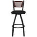 A black metal bar stool with a black vinyl cushion and a walnut wood back.