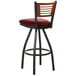 A BFM Seating black metal bar stool with a red vinyl seat.