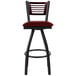 A BFM Seating bar stool with a burgundy swivel seat and black metal frame with a mahogany wood back.