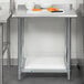 A Steelton stainless steel work table with undershelf and rear upturn.